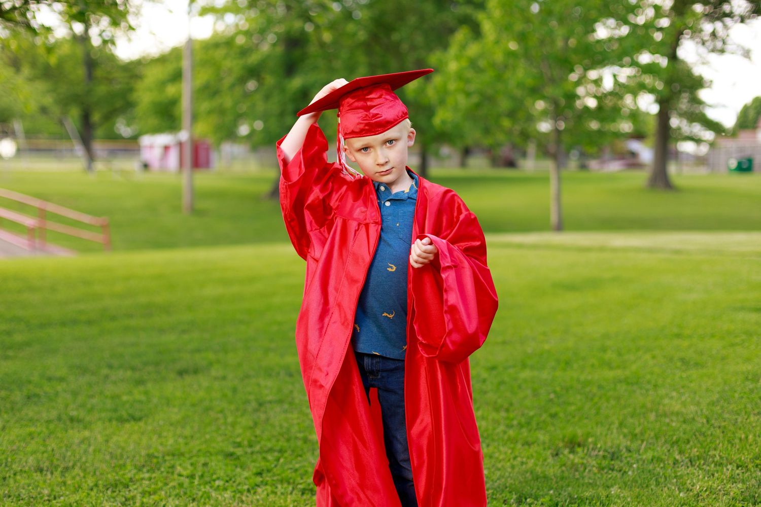 Kindergartener wearing red grad cap and gown