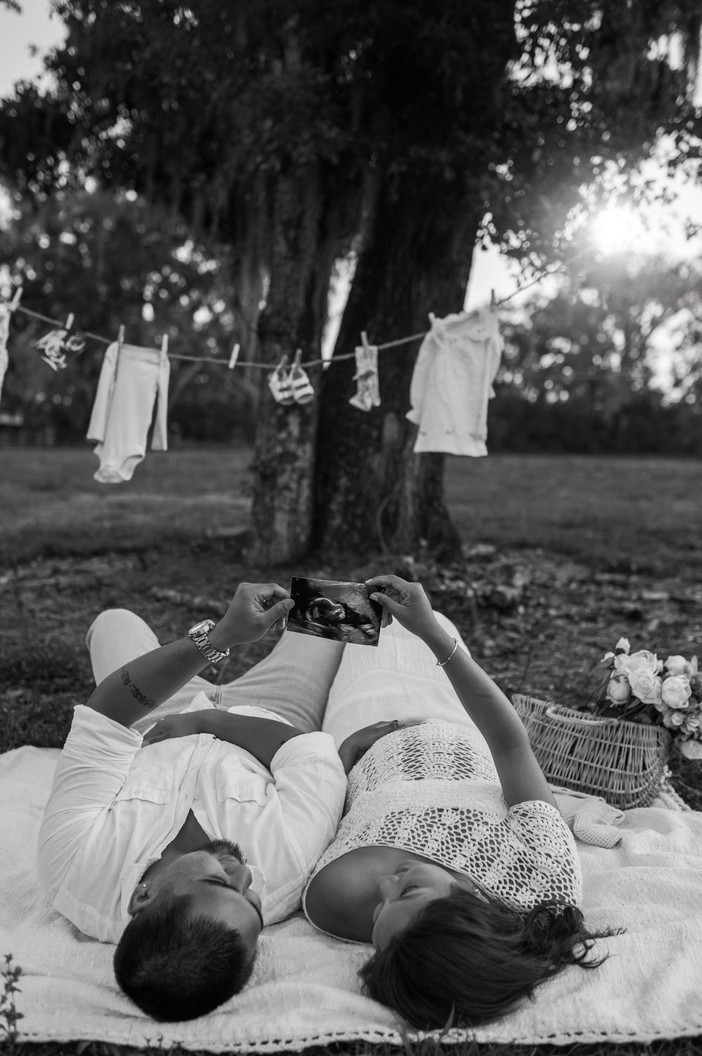 Black and white family photo with white linens hanging on clothesline in outdoor setting.