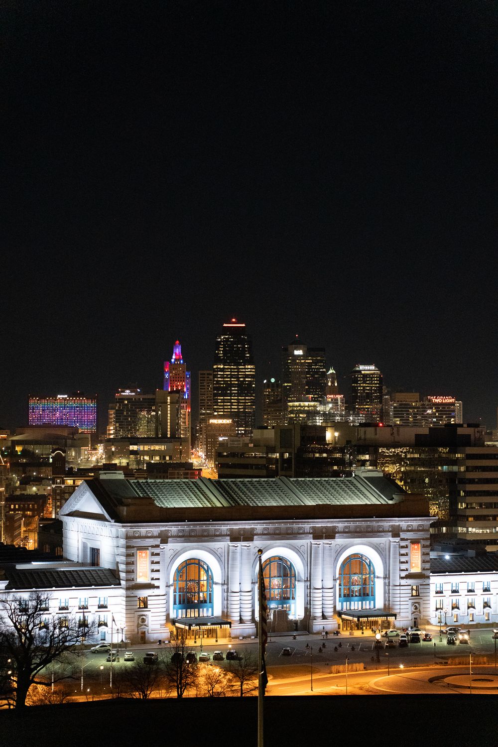 Kansas City's illuminated downtown skyline and Union Station at night with glowing architectural details.