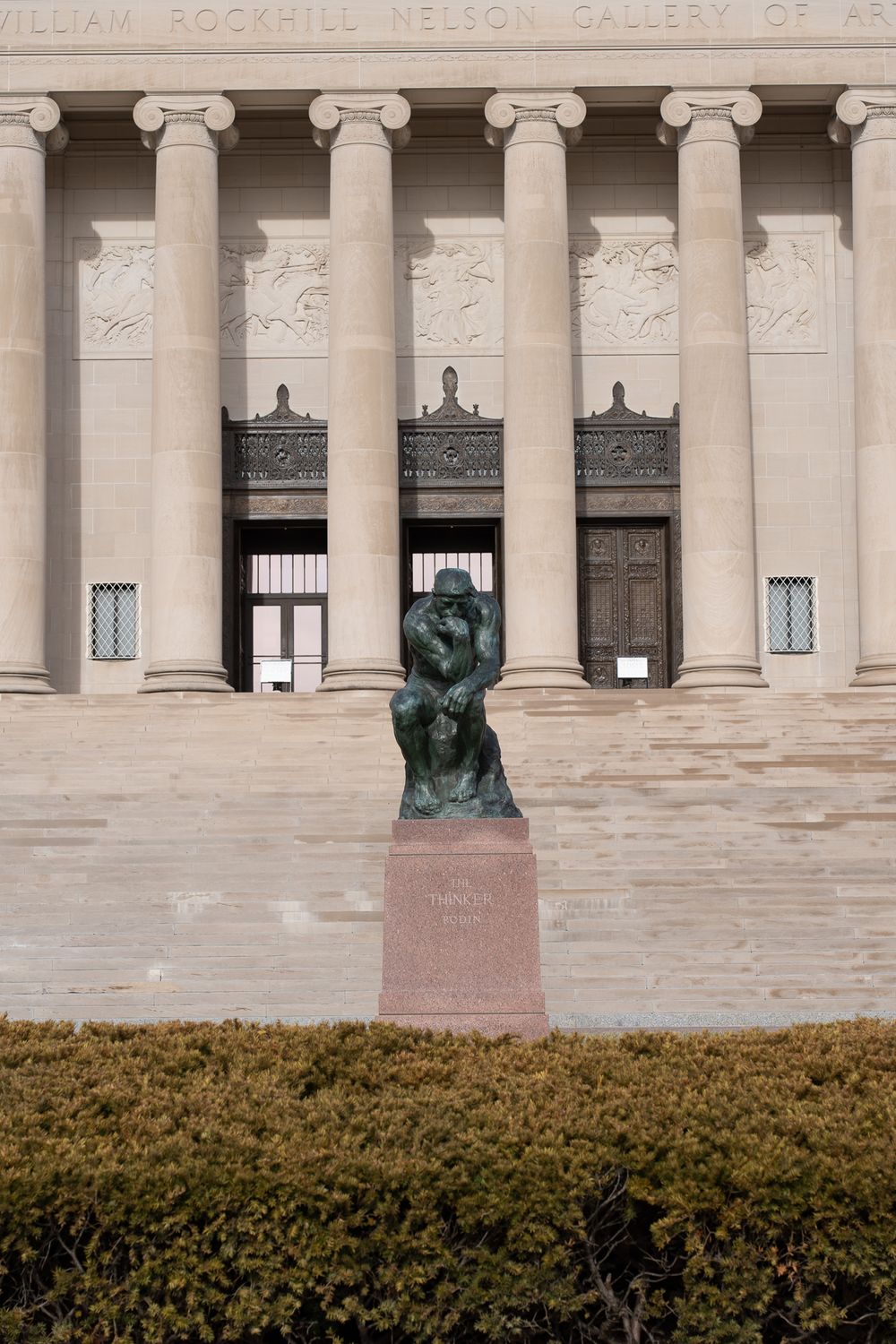 Classical columned facade of Nelson-Atkins Museum with bronze sculpture in foreground.