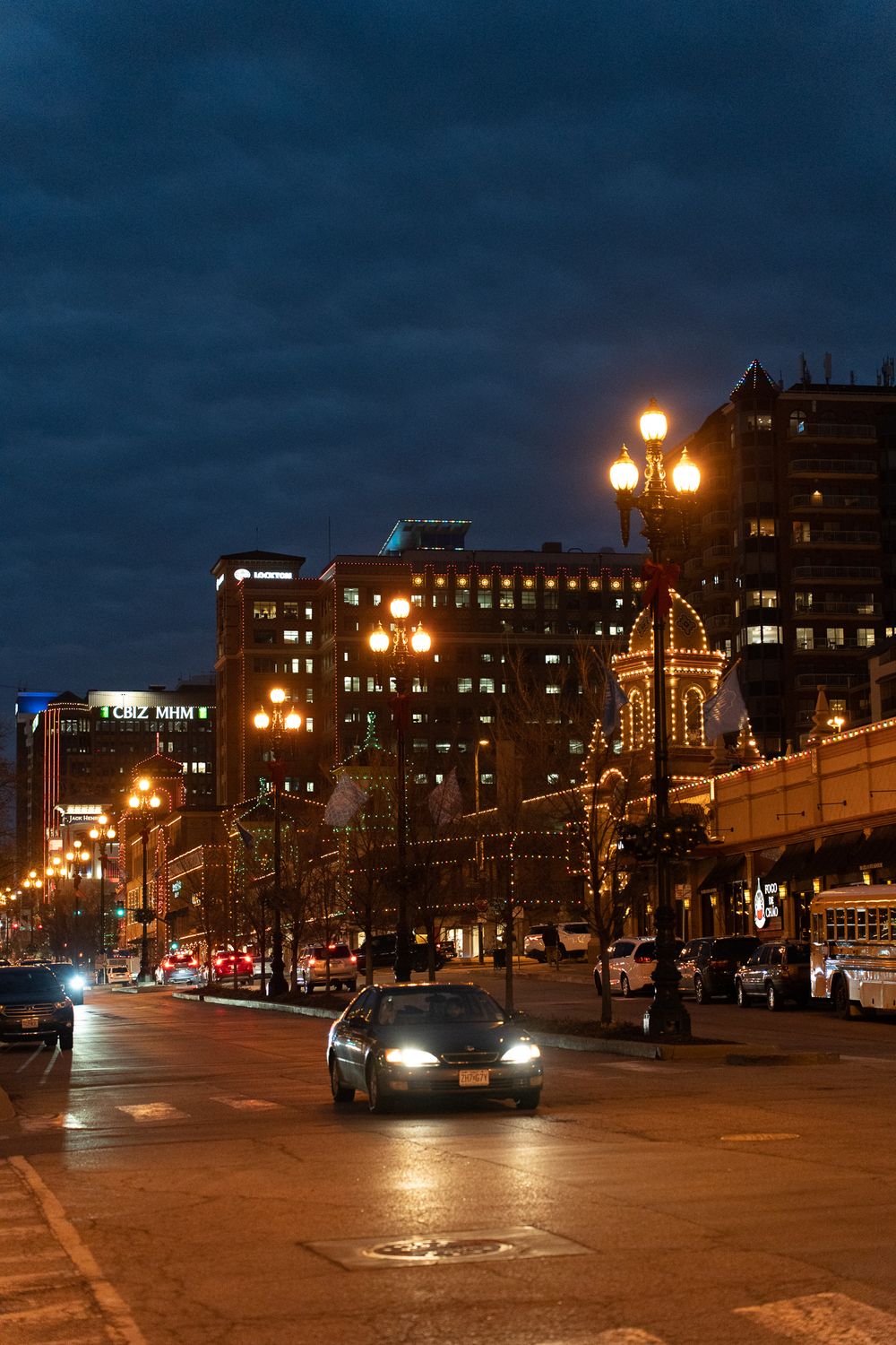 City street at night with illuminated buildings and street lamps creating a moody urban atmosphere.