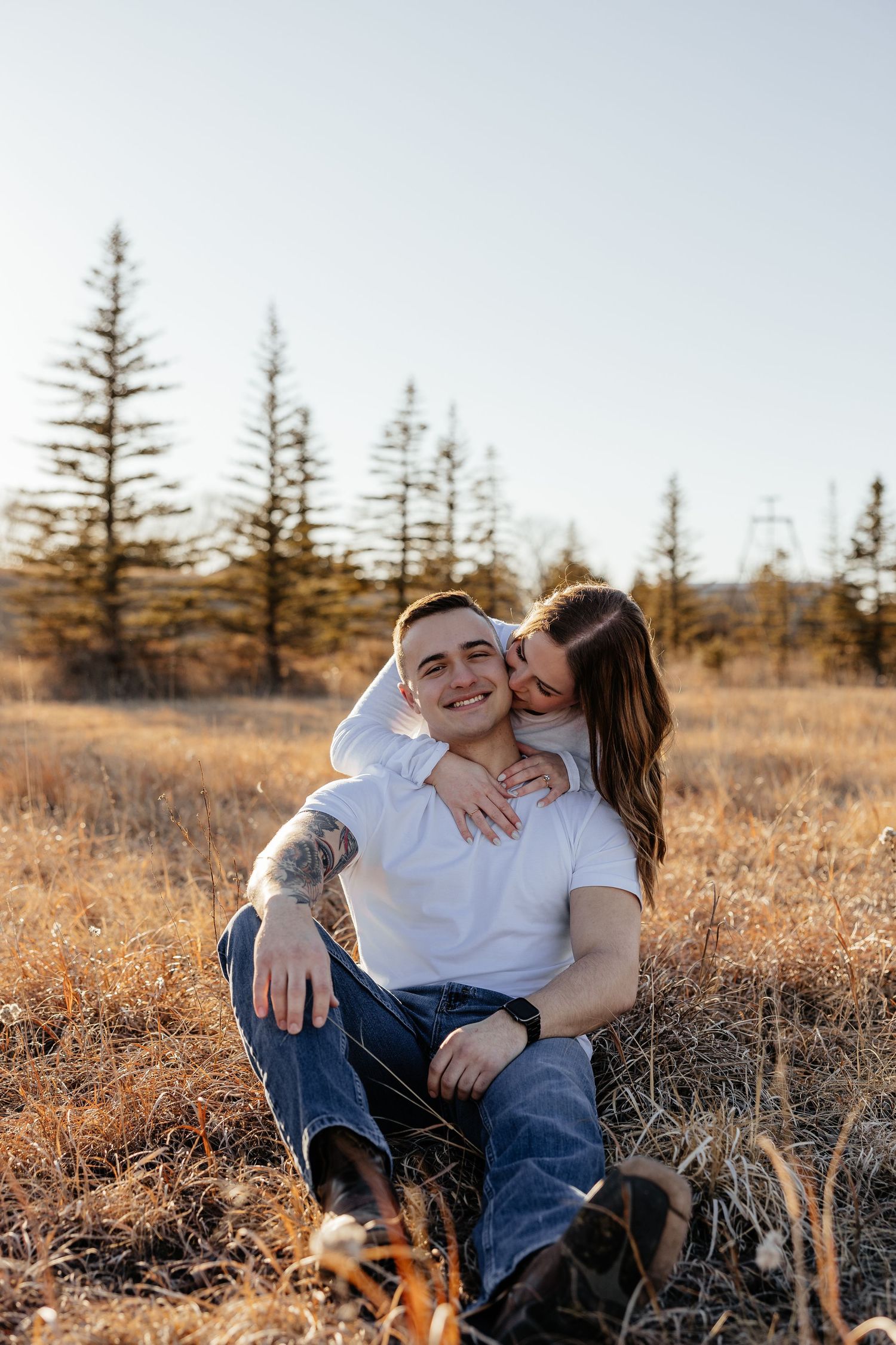 Couple in casual denim and white shirts sharing intimate moments during indoor photo session.