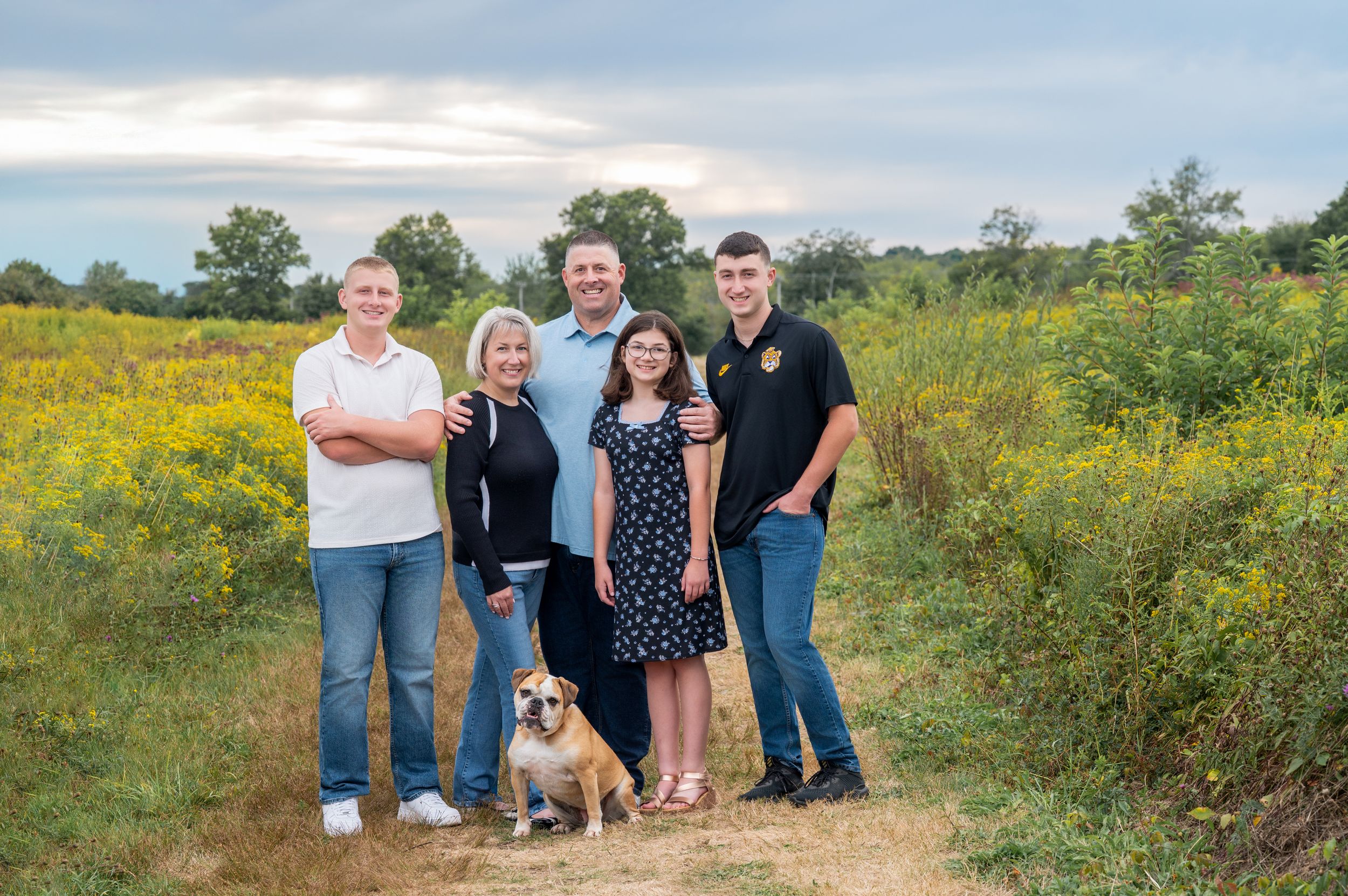 A series of outdoor family photo sessions in a vibrant yellow wildflower field during golden hour.