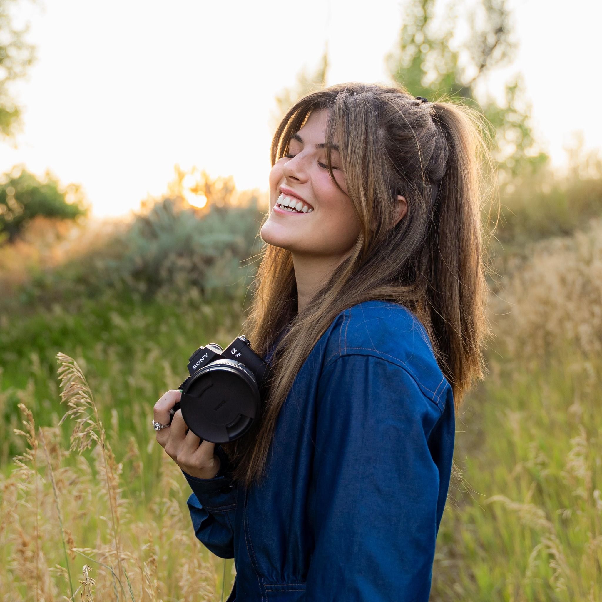 Joyful moments captured in a sunlit field with camera equipment.