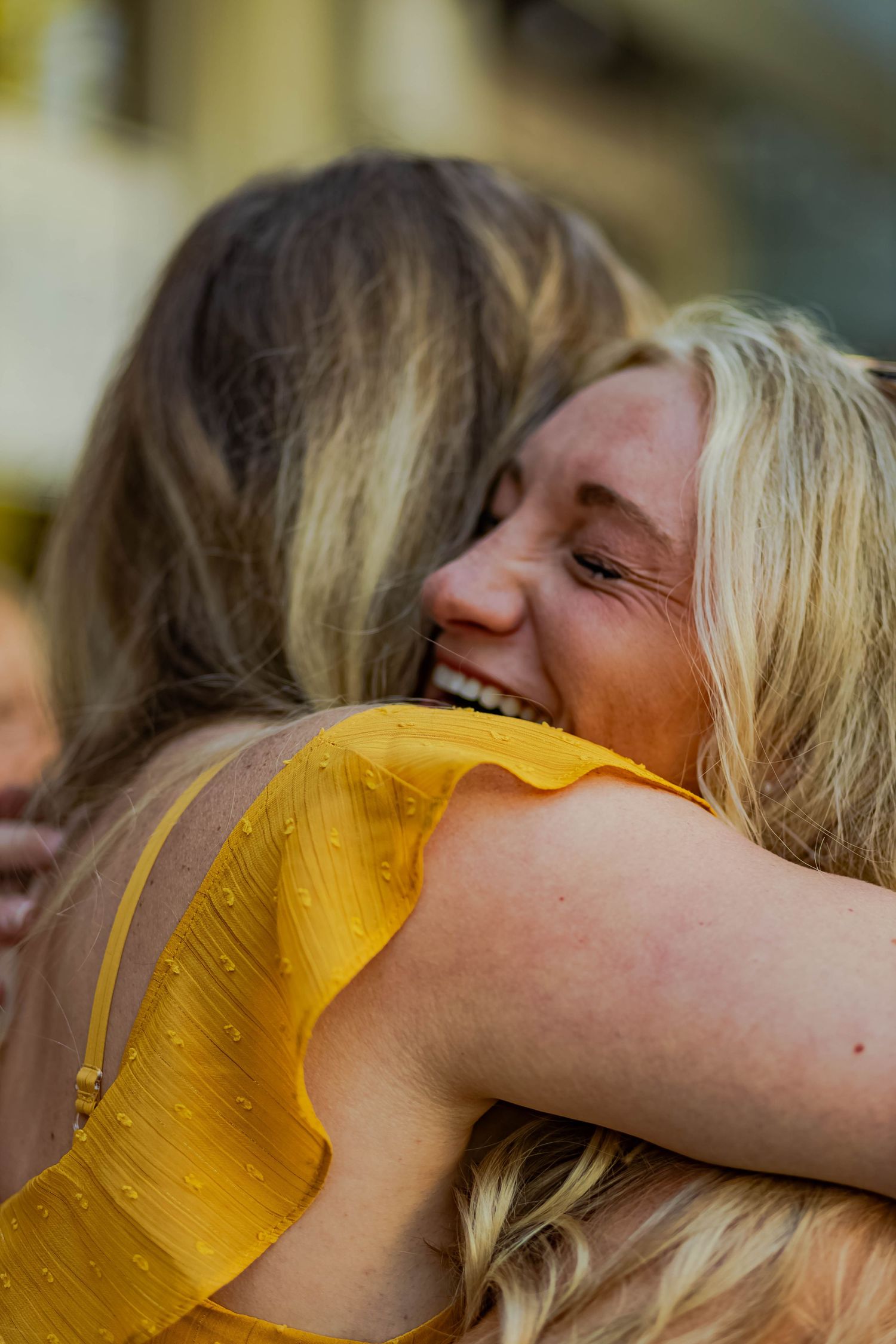 Two people sharing an emotional embrace while celebrating outdoors.