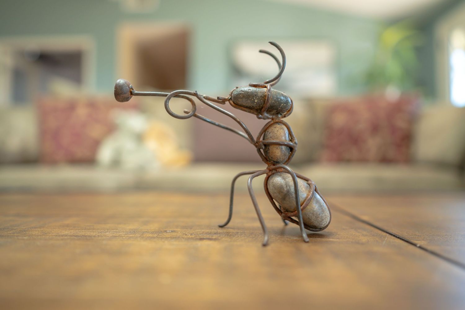An ant playing trumpet is created out of thin twists of metal and rocks. Image demonstrates how f/1.8 aperture creates a blurred background.