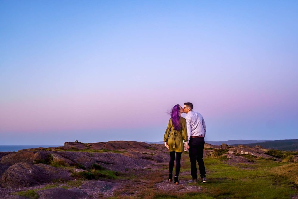 Couple kissing at sunrise at Cape Spear, engagement photo in St. John’s Newfoundland