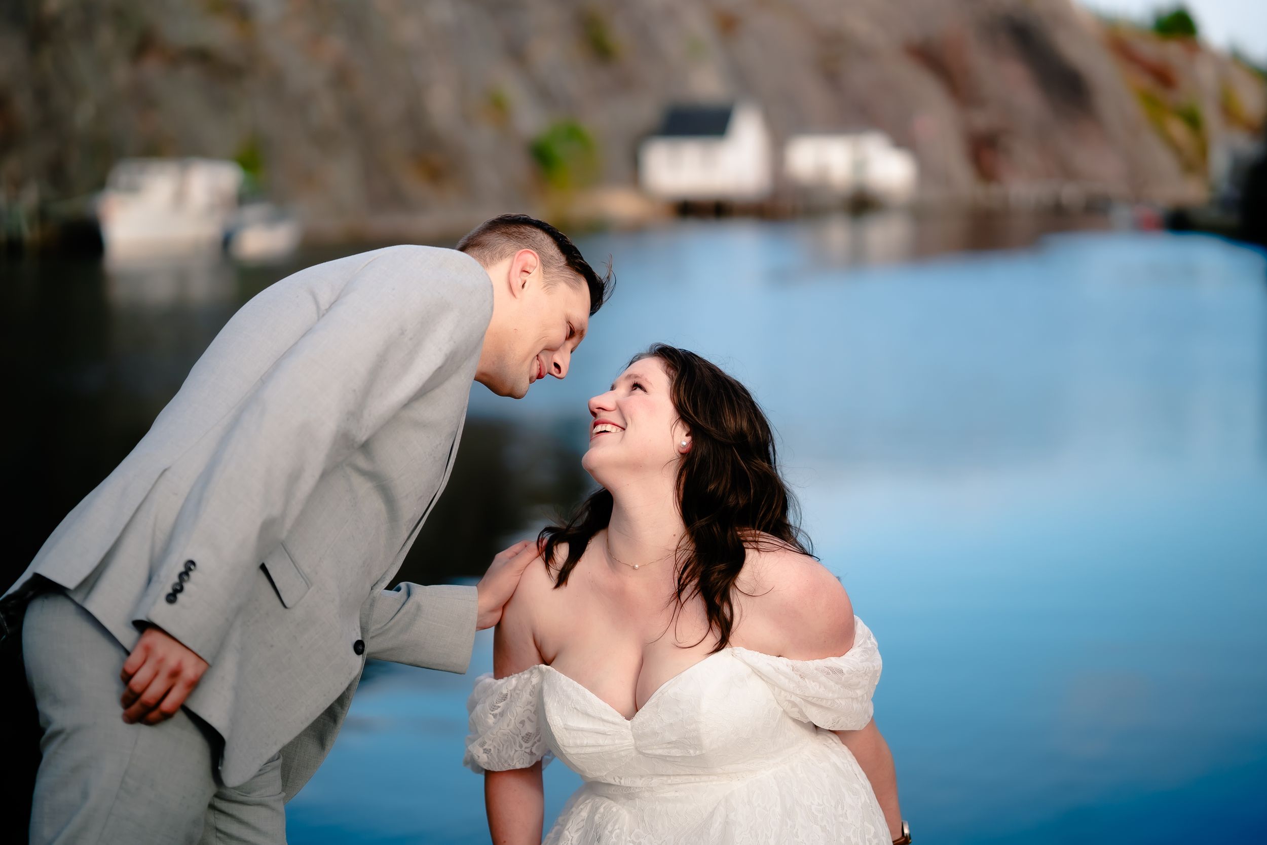 Wedding couple at Quidi Vidi by the sparkling blue water, bride looking lovingly at the groom