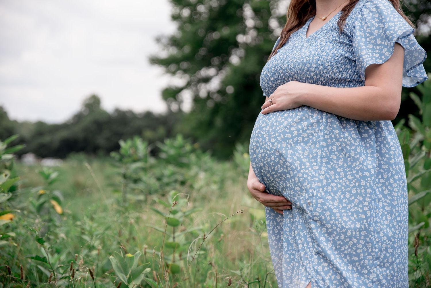 A portrait of a mother embracing her pregnant belly in a field in western Kentucky.