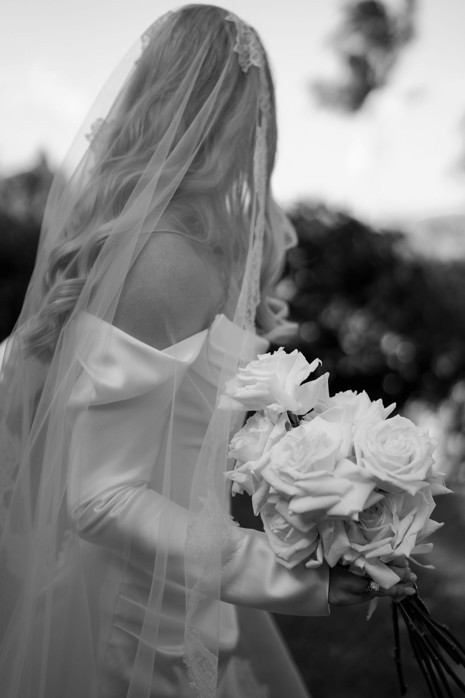 Close-up details of an elegant white lace wedding dress with tulle layers.