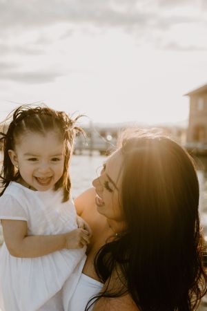 Sunlit portrait of joy and laughter shared between parent and child.