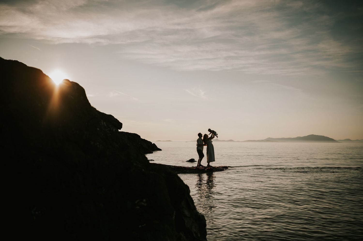 Silhouette of parents holding baby up on Beach in Neck Point Nanaimo Vancouver Island. Photography by Photographer Soulfull Photographs