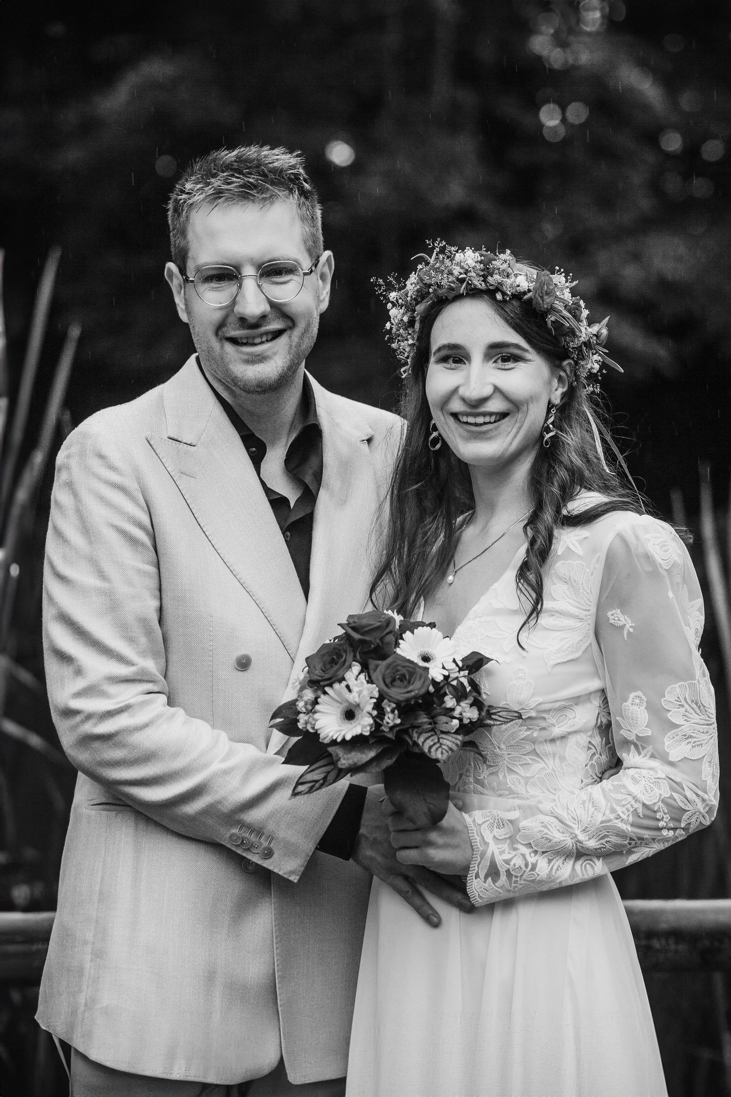 Loving couple embraces in a wheat field during sunset, creating a romantic black and white portrait.
