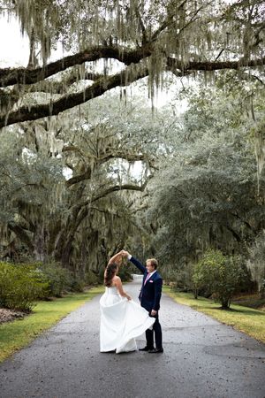 Elegant wedding portraits taken on a path beneath dramatic Spanish moss covered oak trees.