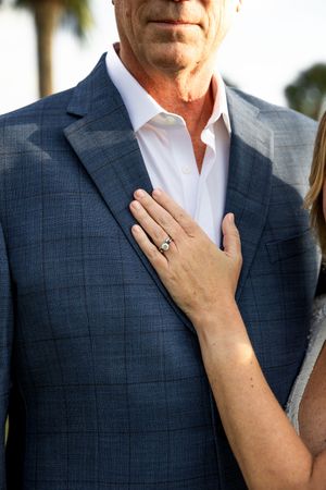 Close-up view of a navy blue textured suit jacket with white dress shirt detail.