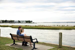 A scenic waterfront view with benches overlooking the ocean and coastal marshland.