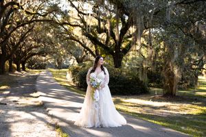 A dreamy outdoor photo session under a canopy of oak trees with Spanish moss in a romantic garden setting.