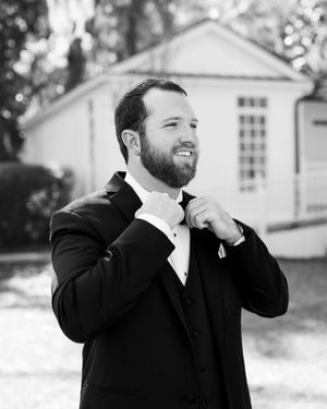 A sequence of black and white photos shows a person in a suit adjusting their tie and collar in various poses.