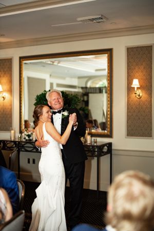 A touching dance moment captured at an elegant indoor wedding reception.