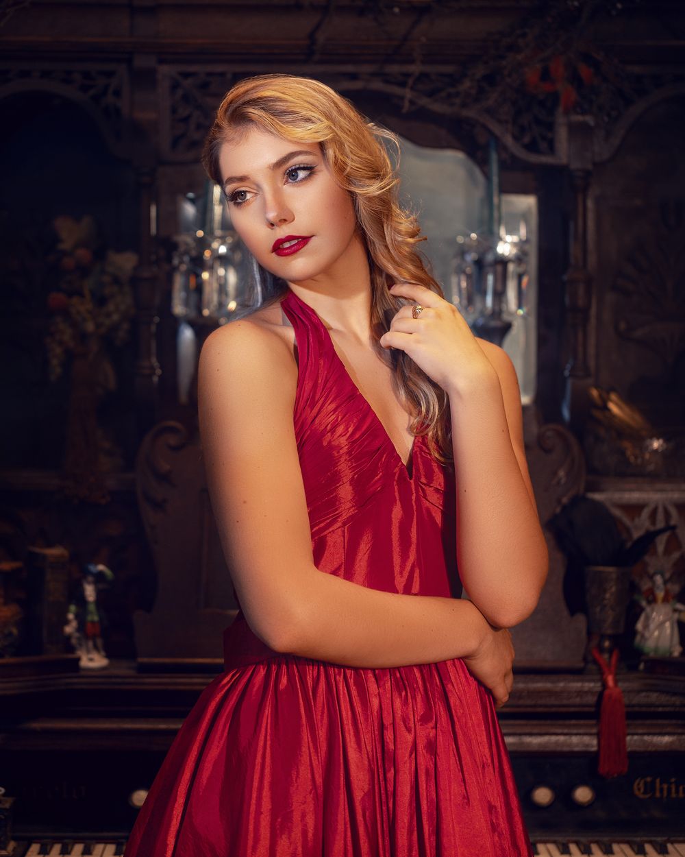 Elegant portrait in red silk dress against vintage interior setting.