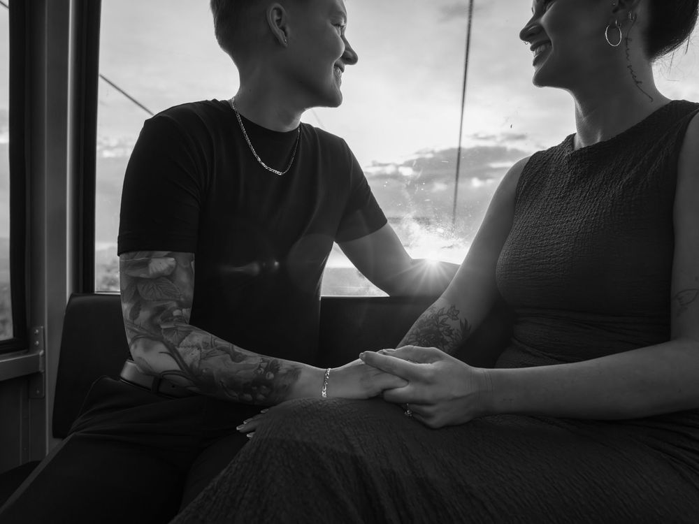 Two people sit in silhouette against bright sunlight streaming through a window during a quiet moment together.