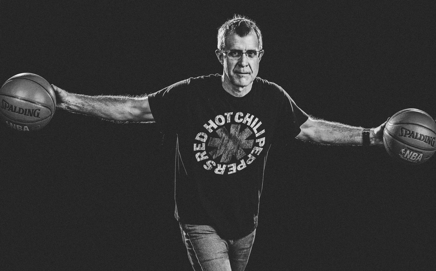Portrait of Flagstaff photographer Sean Openshaw palming basketballs while on a team sports photoshoot.