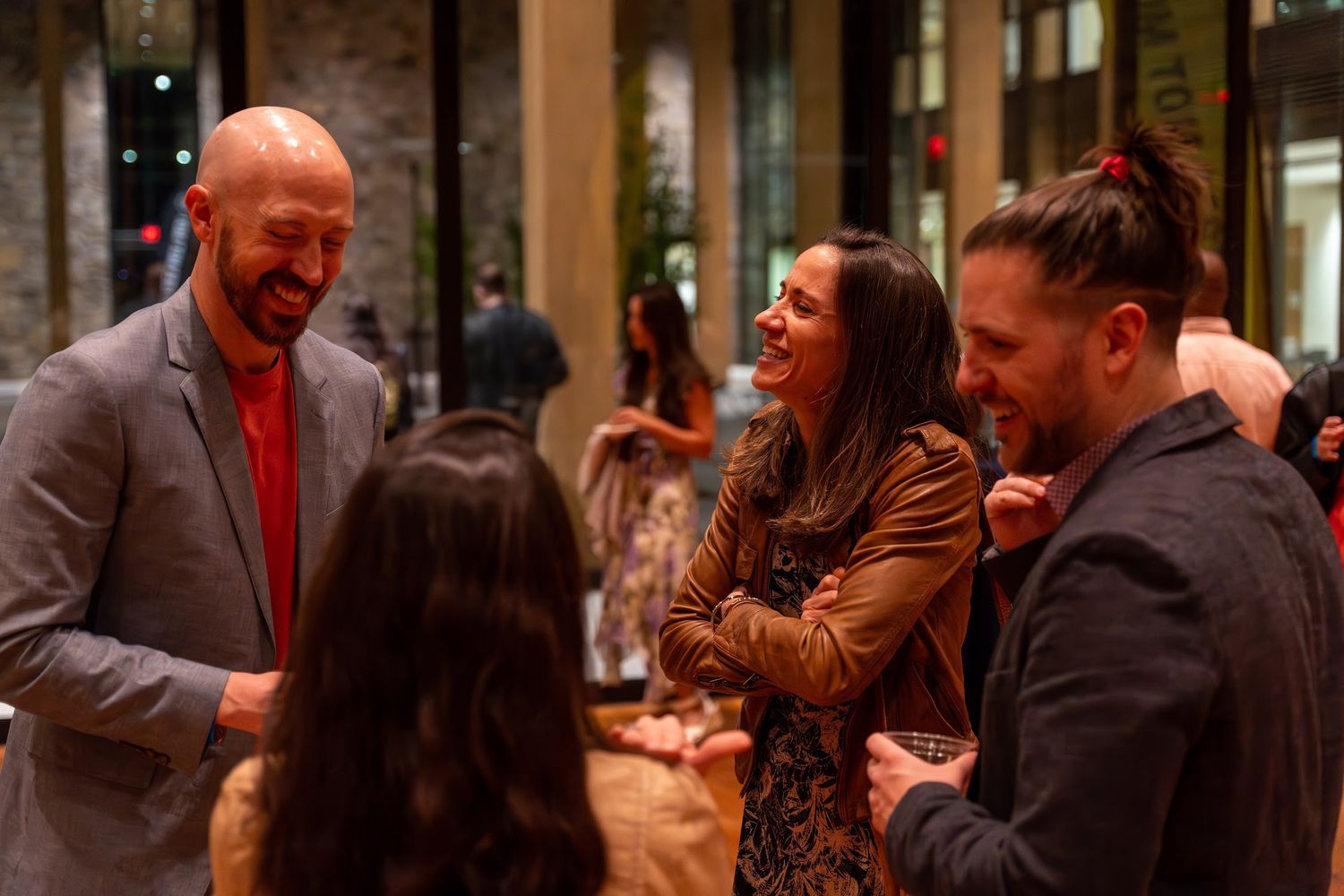 A group of people laughing and socializing at a lively party or gathering.