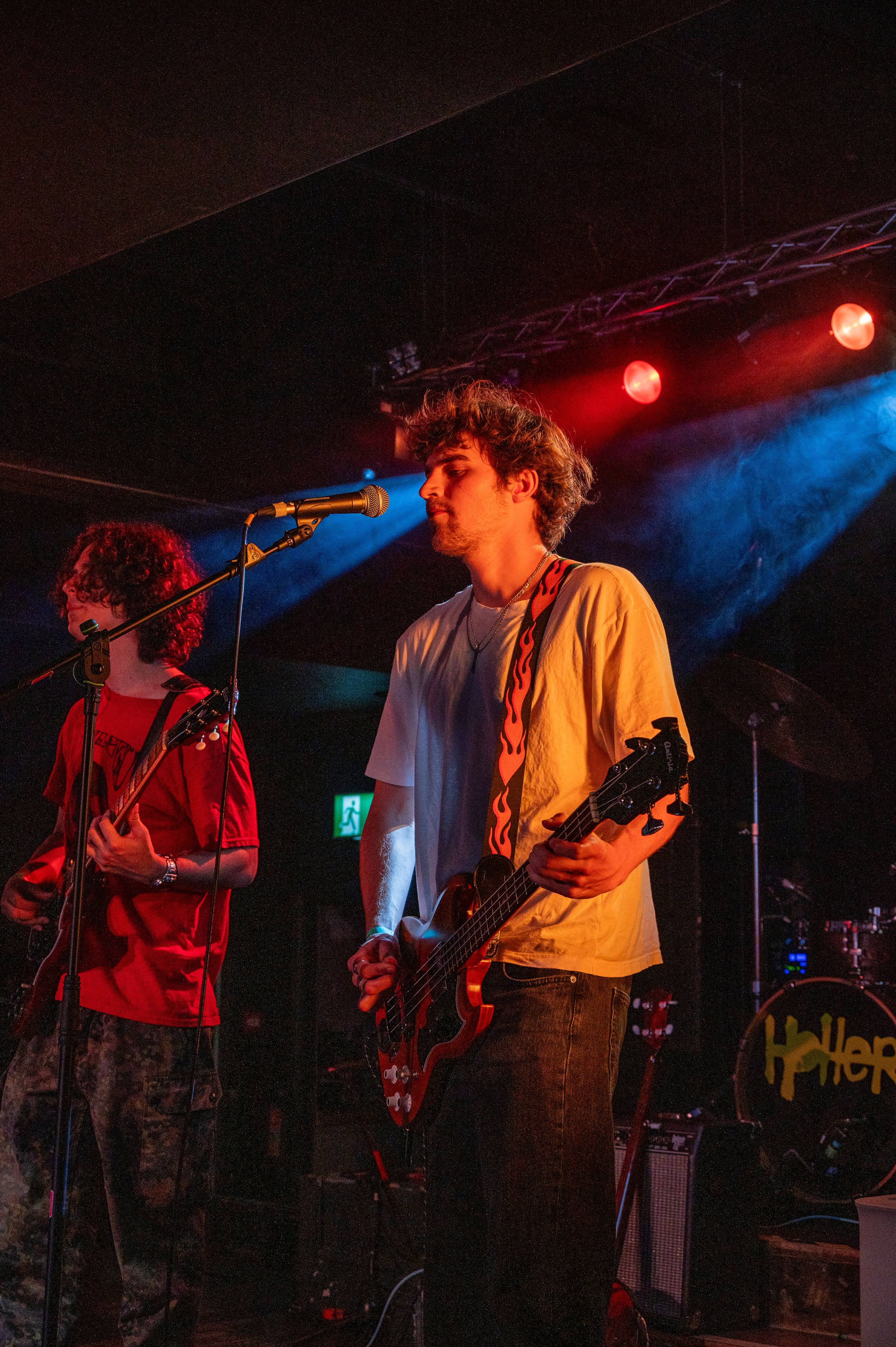 Musicians performing on stage with dramatic red and blue lighting effects.