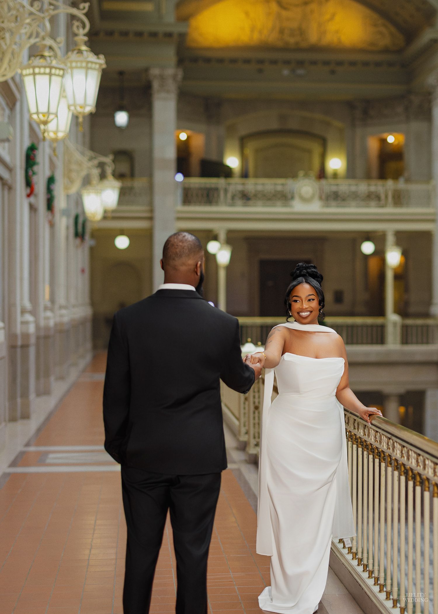 A romantic wedding moment with a couple in white attire sharing a kiss while holding a blue and white bouquet.