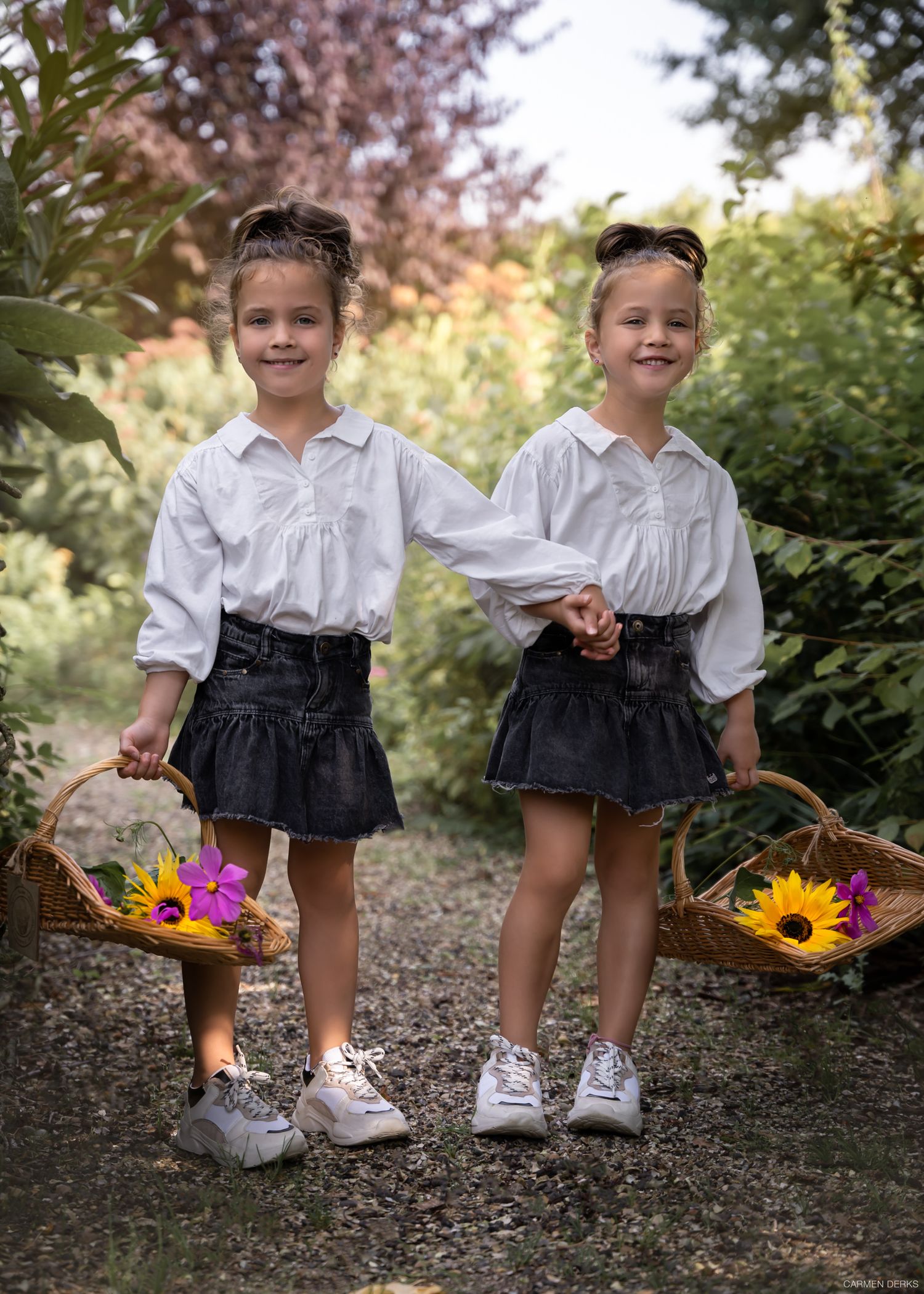 foto van twee meisjes in pluktuin met mandjes met geplukte bloemen