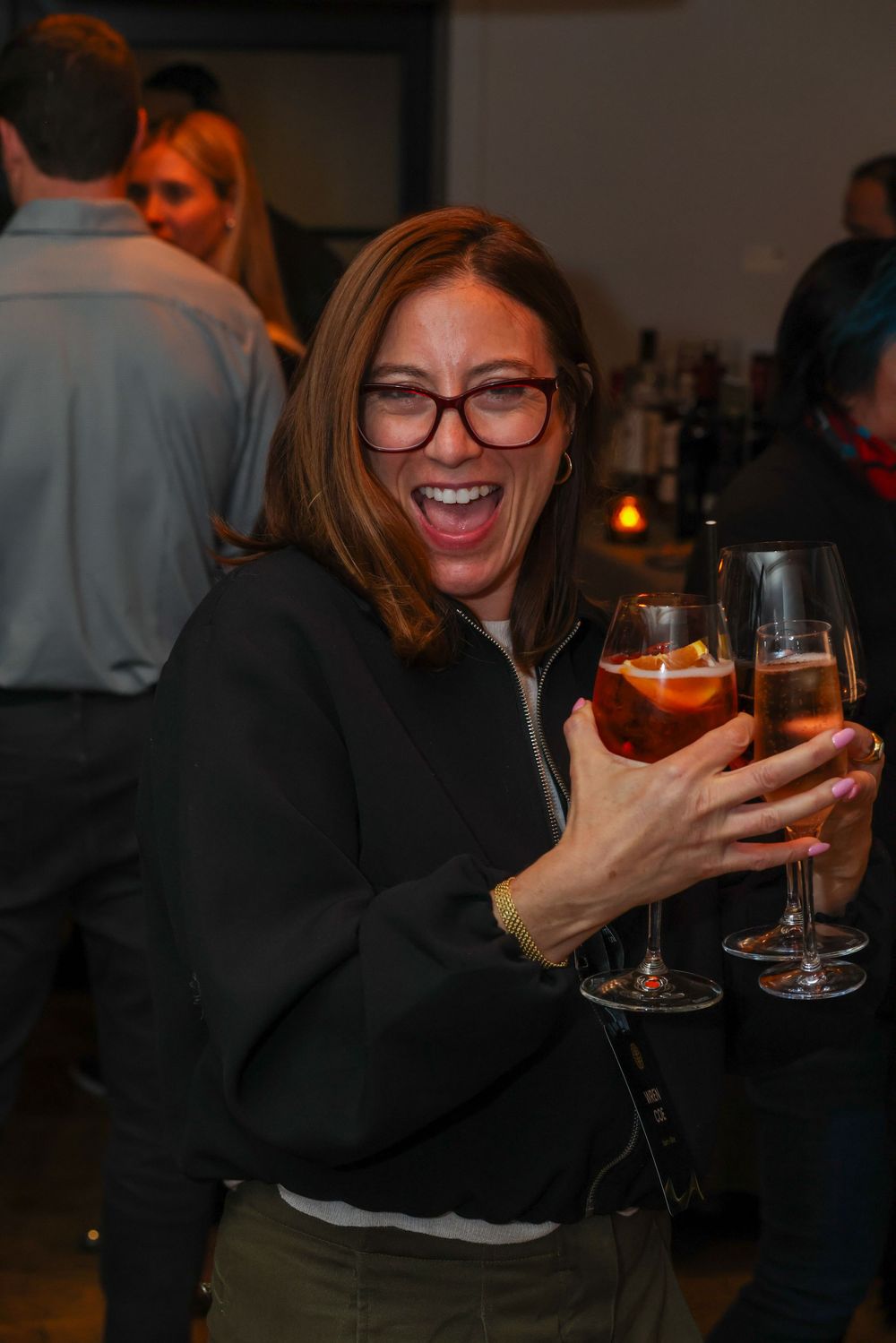 A sequence of candid shots showing someone enjoying a glass of wine in a dimly lit setting with laughter and joy.
