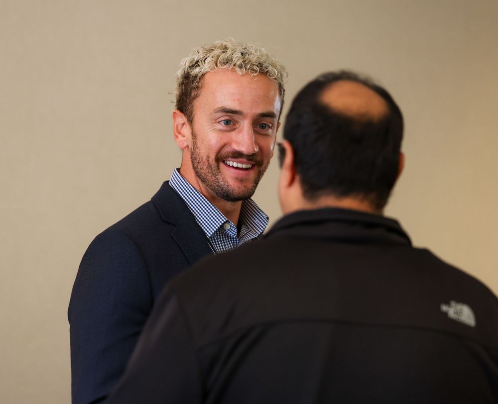 A sequence of five photos showing two people in business attire having an animated conversation and laughing together.