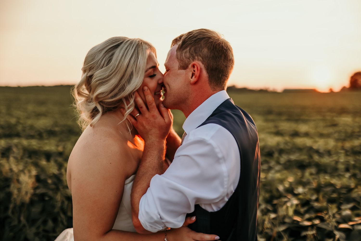 Intimate sunset wedding portrait with couple sharing tender moment.
