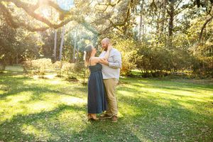 A series of romantic moments captured in a sunlit park with moss-draped trees.