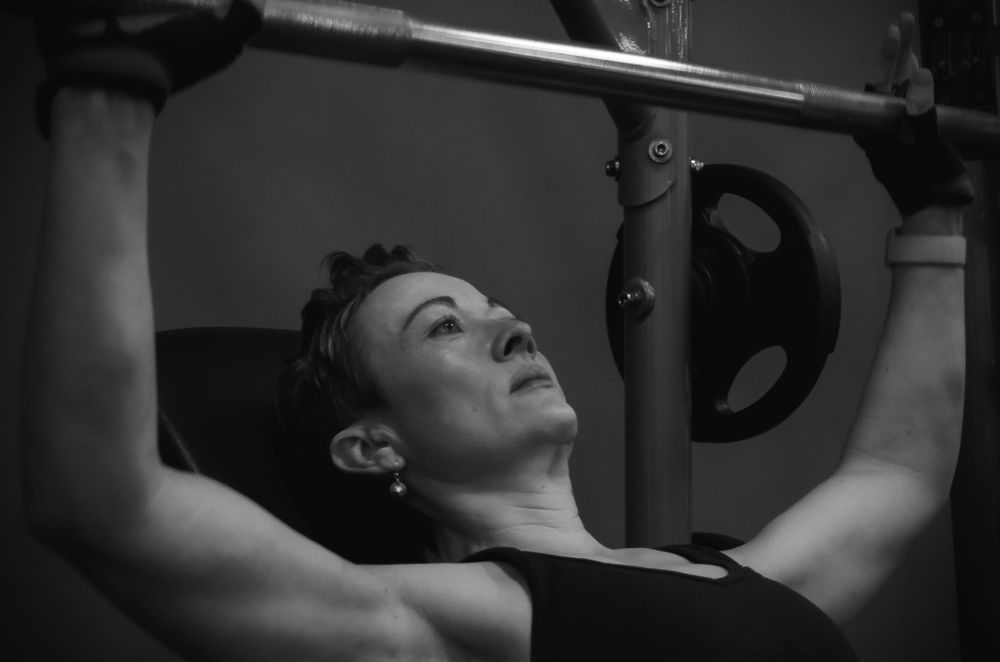 A person performs pull-ups on an exercise bar during an intense workout.