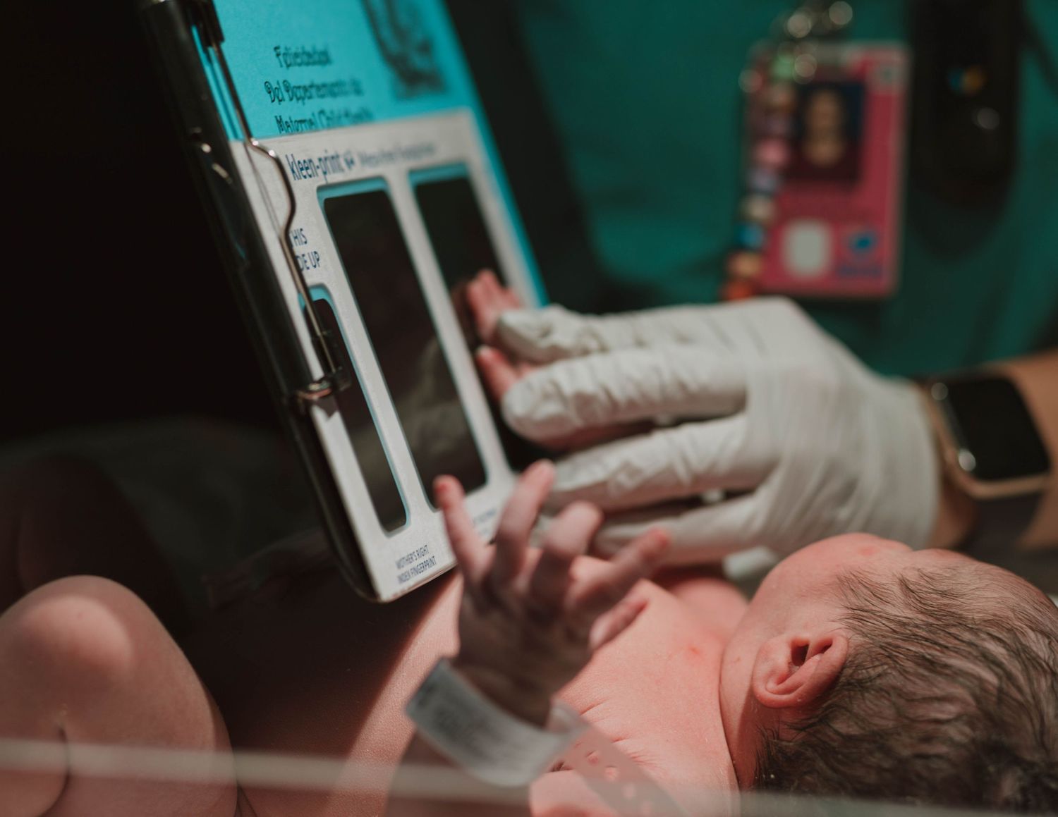 Medical professional examining newborn baby in hospital setting.