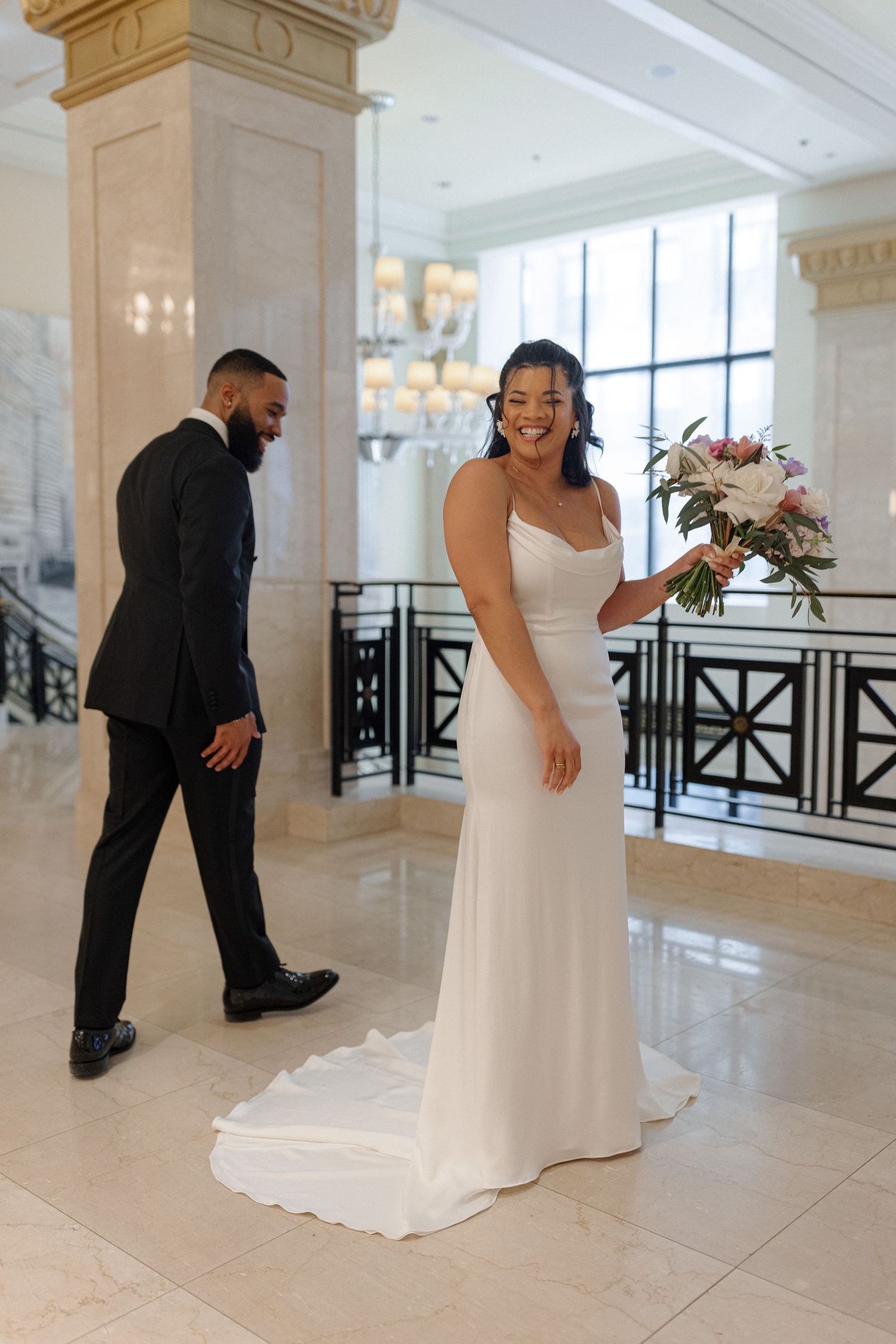 An elegant wedding moment captured in a marble-pillared venue.