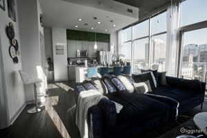 Spacious modern living room with navy blue sofas and floor-to-ceiling windows with a city view.