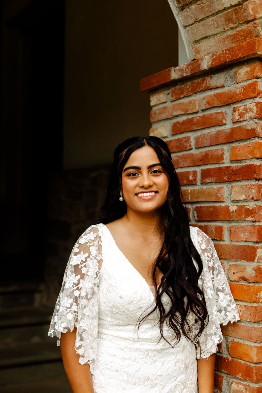 A sequence of warm-toned portraits against a brick wall showcasing a white lace dress.