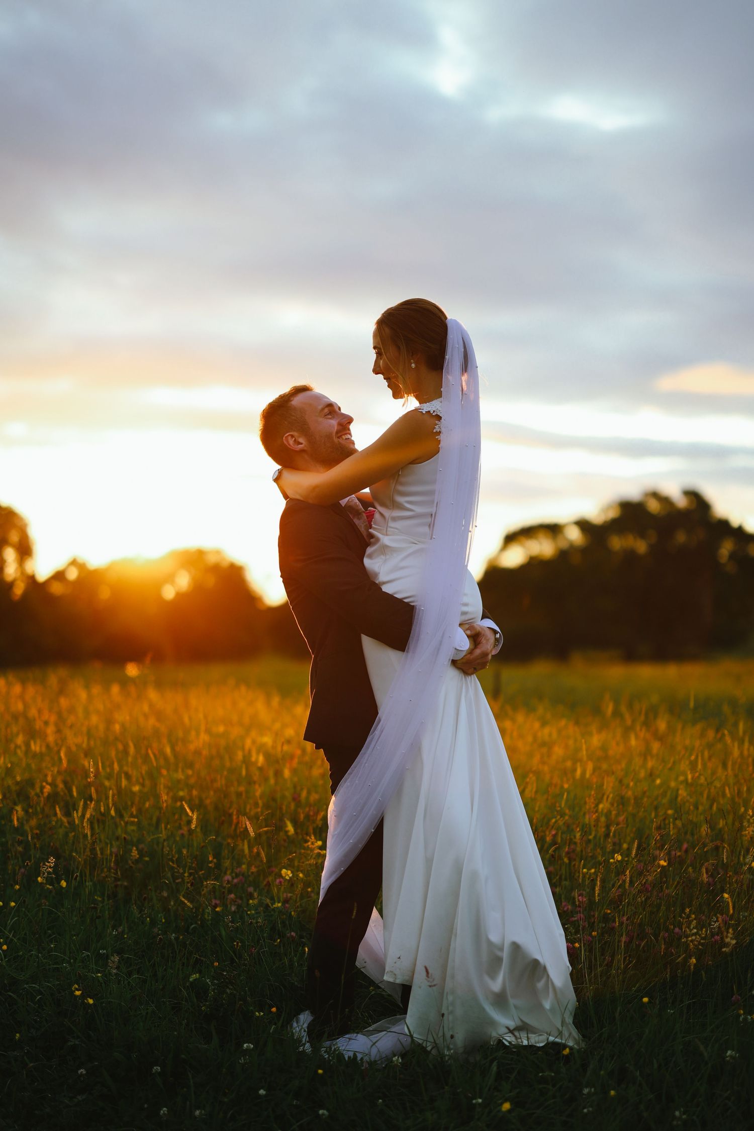 A couple shares a joyful moment on white marble steps inside an elegant church with stained glass windows.
