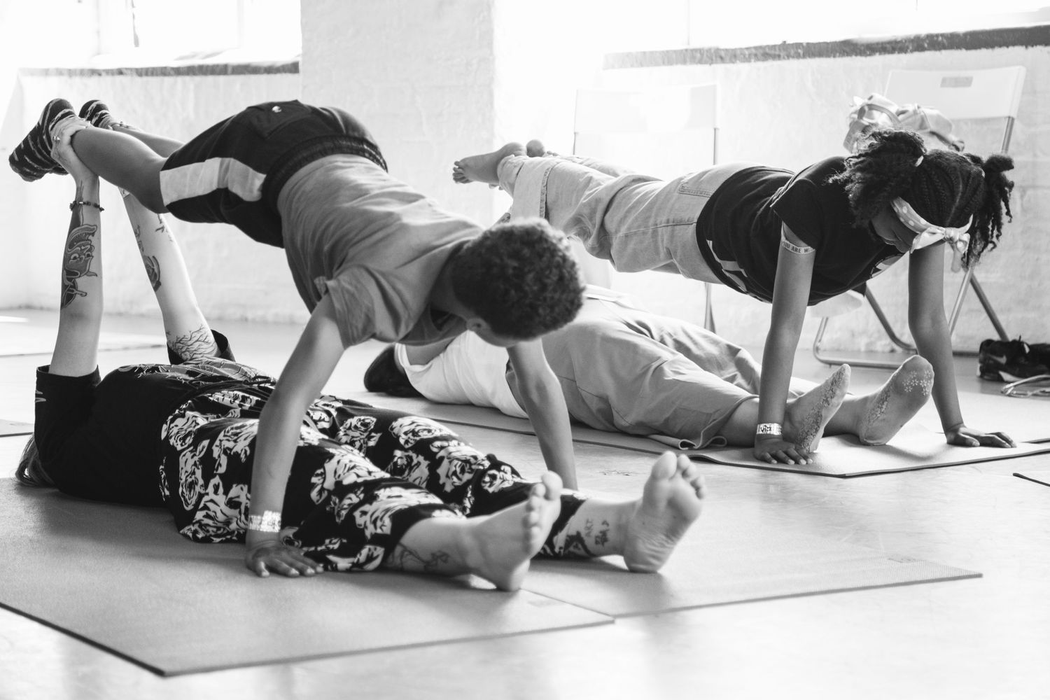 Black and white image showing participants in plank position during a group exercise class.