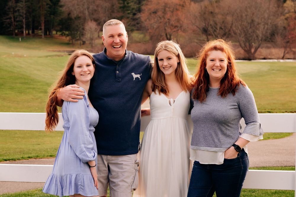 A Family with Teens and college graduate with beautiful grassy backdrop