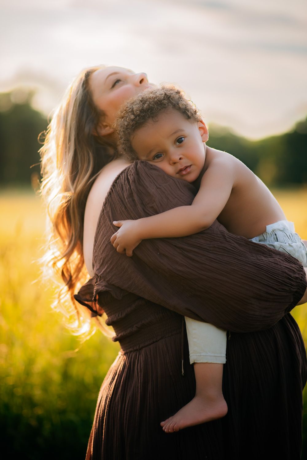 A pregnant mama and her toddler son having a peaceful loving moment while posing for her Maternity Photoshoot in Westborough MA