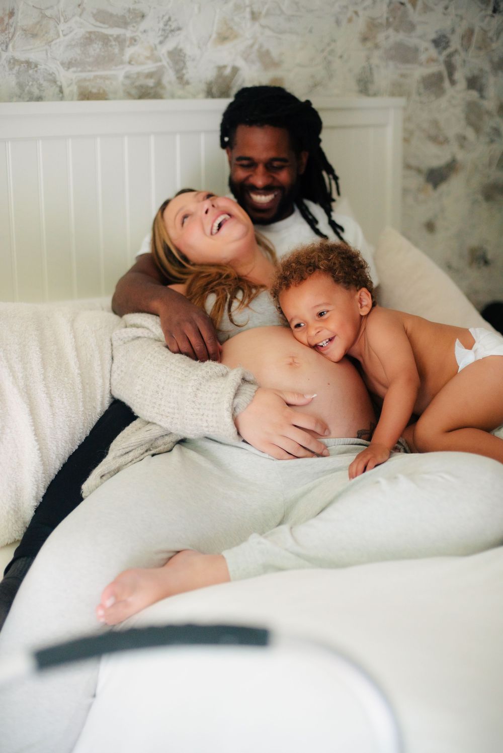 A mama cracking up over her toddlers antics in an at home maternity photoshoot massachusetts