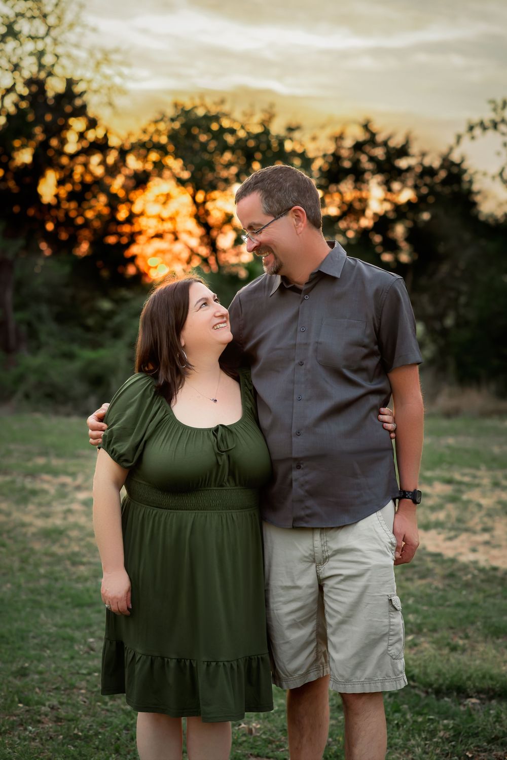 A couple with a sunset backdrop gazing at each other