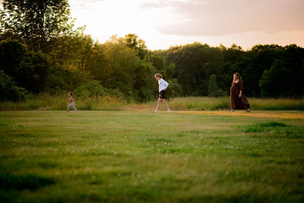 sweet image of a mama and her two kids walking in a line like her little chickadees during maternity session