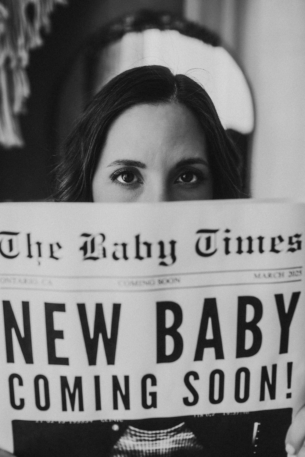 Newspaper style pregnancy announcement with text reading 'New Baby Coming Soon'.