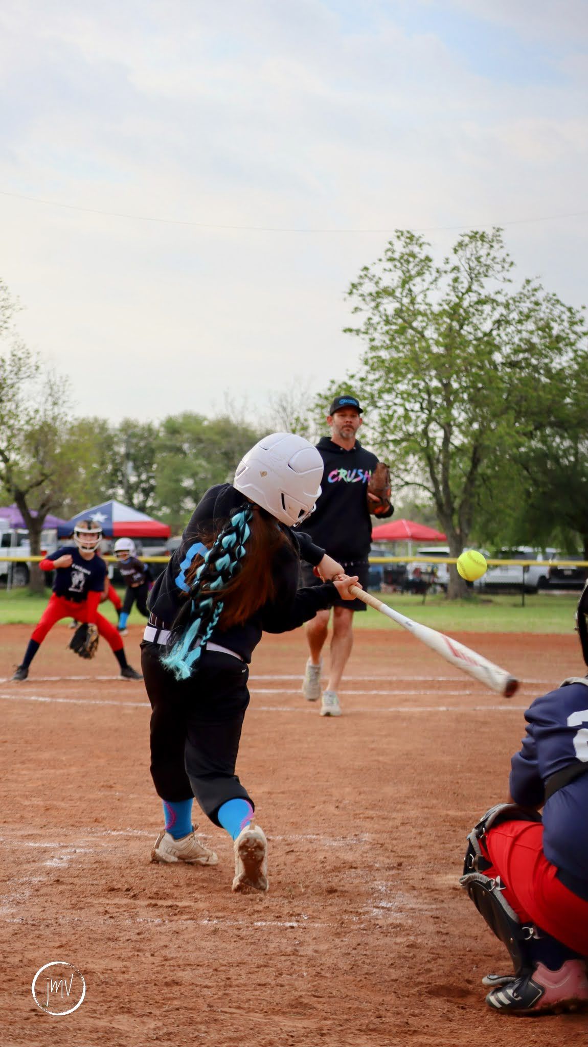Softball player executing dramatic sliding play on dirt infield in action sequence photography.