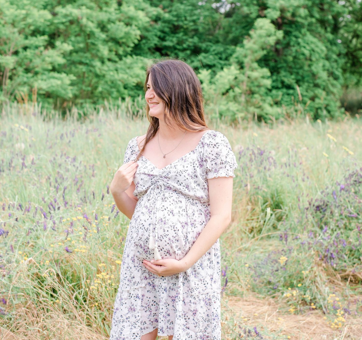A floral dress photoshoot in a lush green meadow with wildflowers on a sunny day.