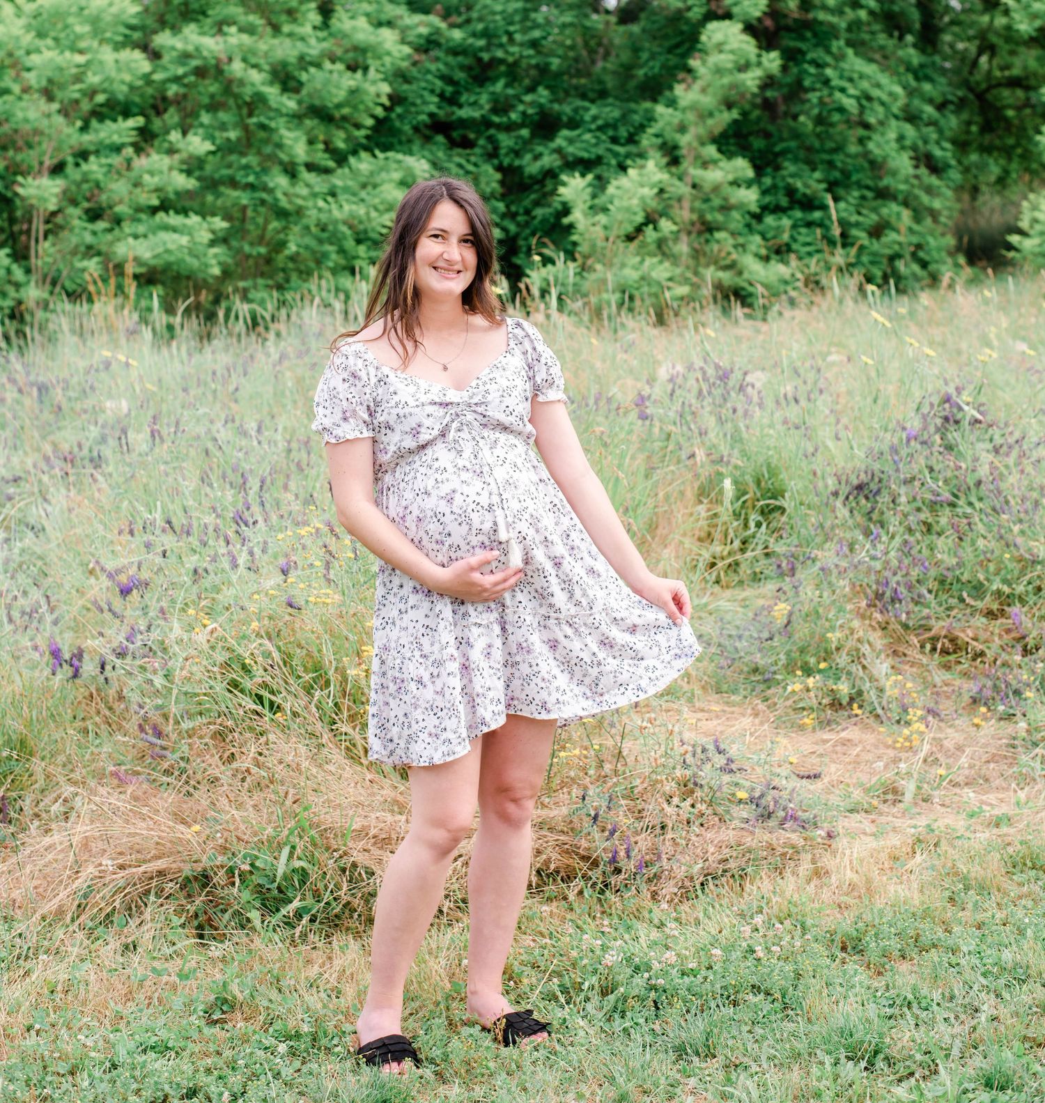 A relaxed summer maternity session in a beautiful grassy field with natural lighting.